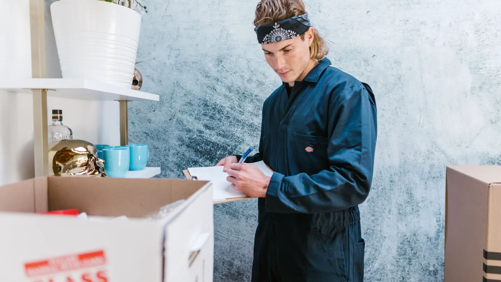 A worker holds a clipboard near a battery container on a construction site