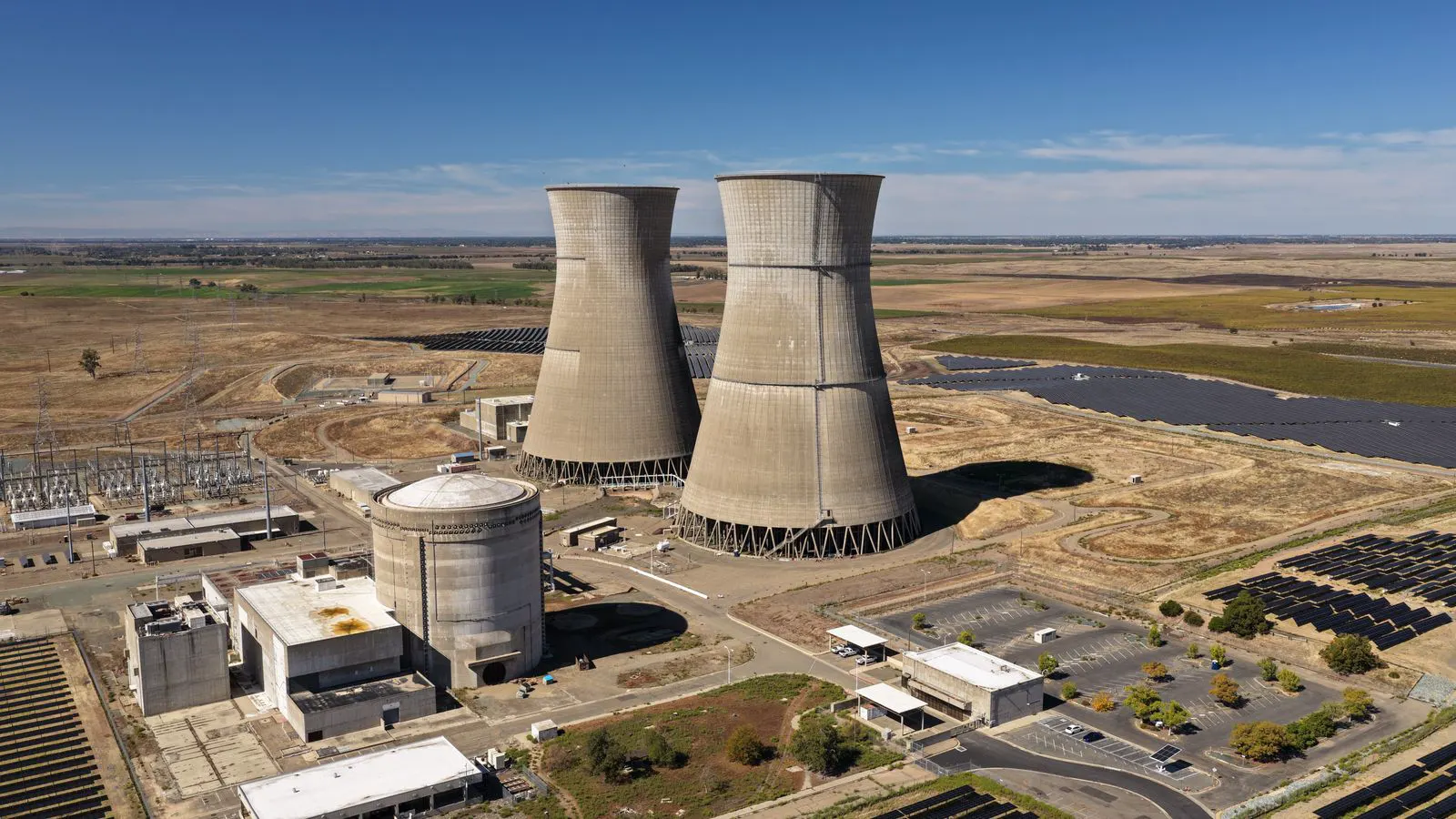 A large outdoor battery enclosure array at a grid facility during daylight.