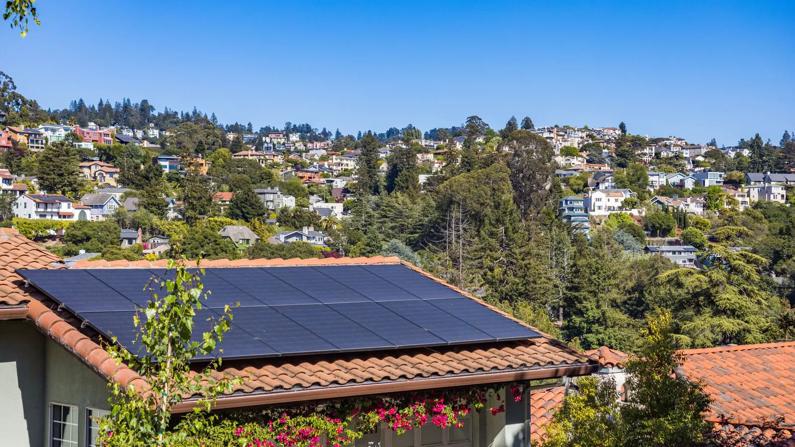A residential battery install scene showing a wall-mounted storage unit near a utility meter