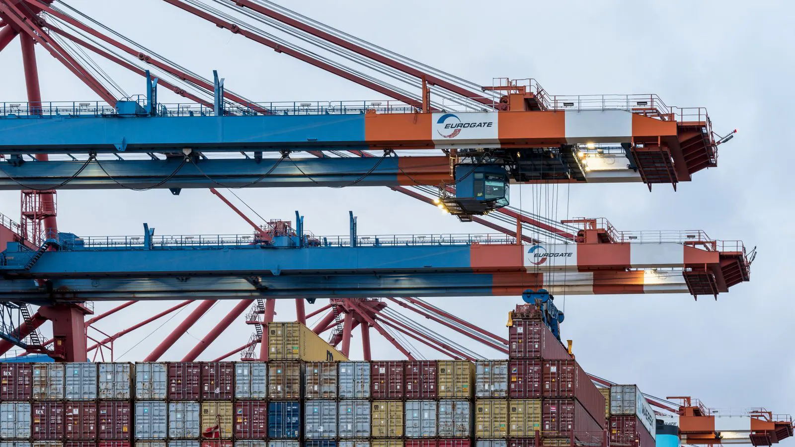 A truck loading a shipping container into a warehouse bay