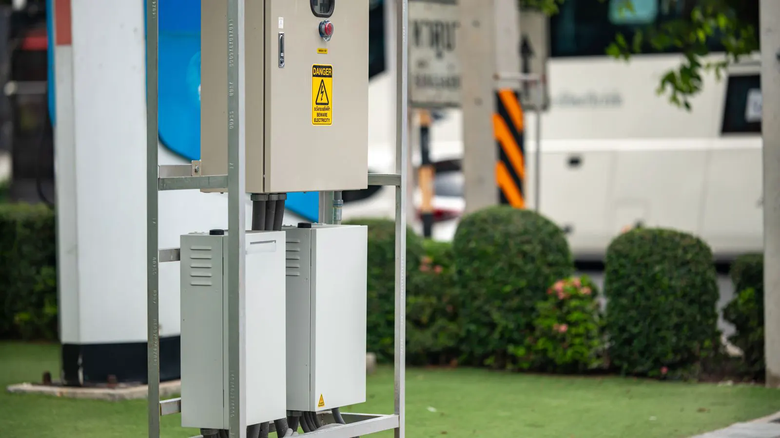 A row of wall-mounted electric vehicle charging units in a testing facility.