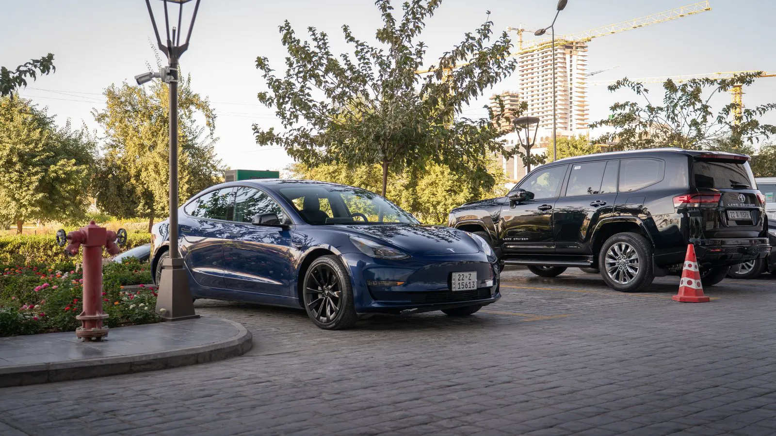 A modern electric vehicle charger installed near an office building entrance.