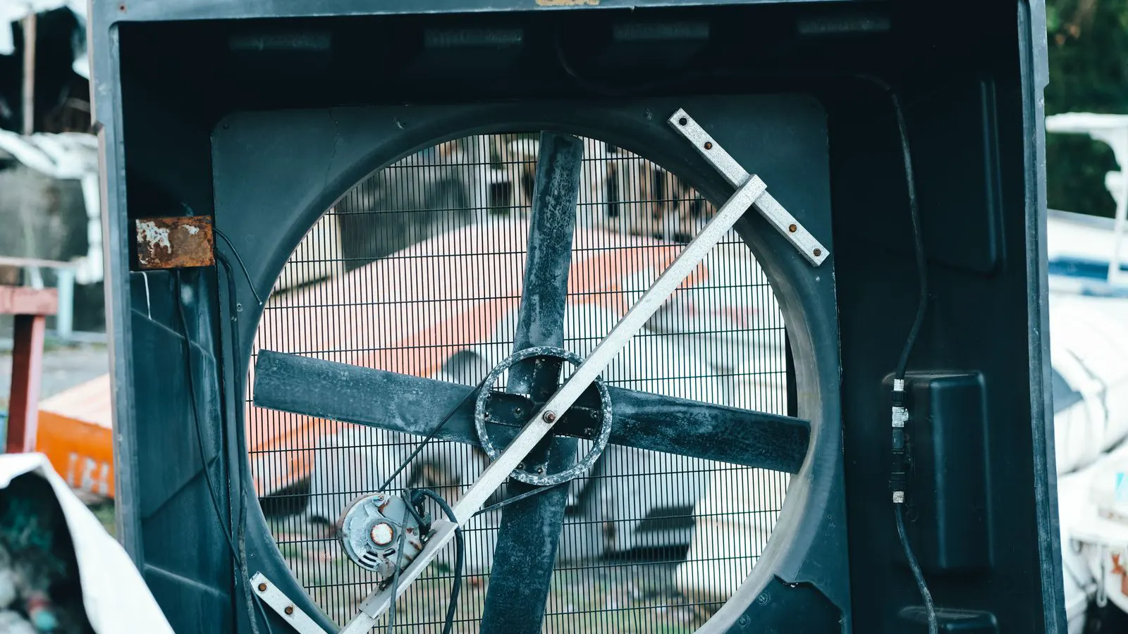 Multiple electric fans mounted on a metal heat exchanger frame outdoors