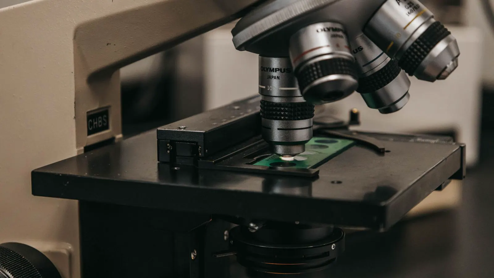 A laboratory instrument analyzing an aluminum sample with a focused beam of light
