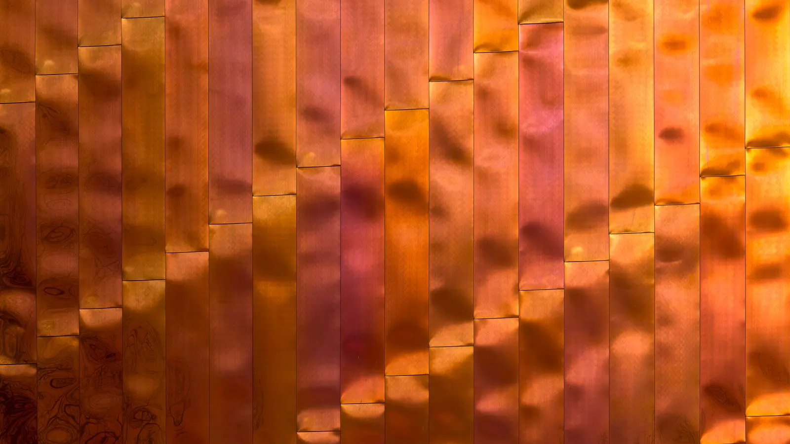 A neat stack of thick copper sheets on a workbench