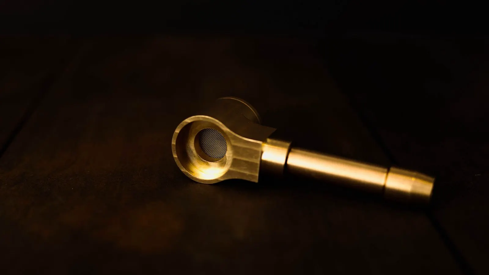Close up of a worker using a flashlight to check a brass pipe