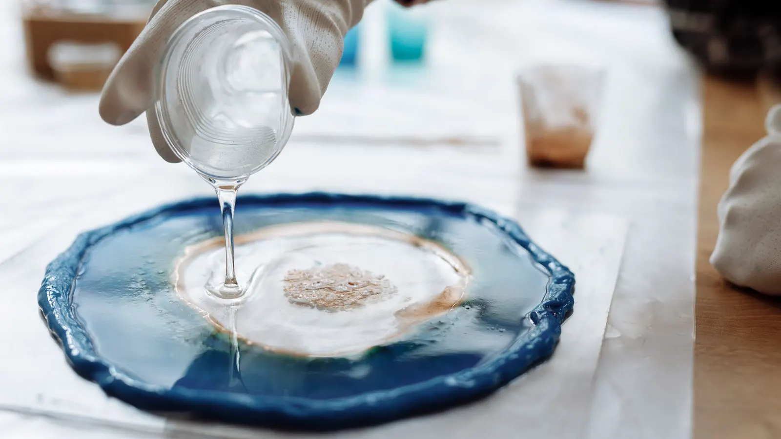 Worker inspecting a sample of plastic resin pellets in a warehouse