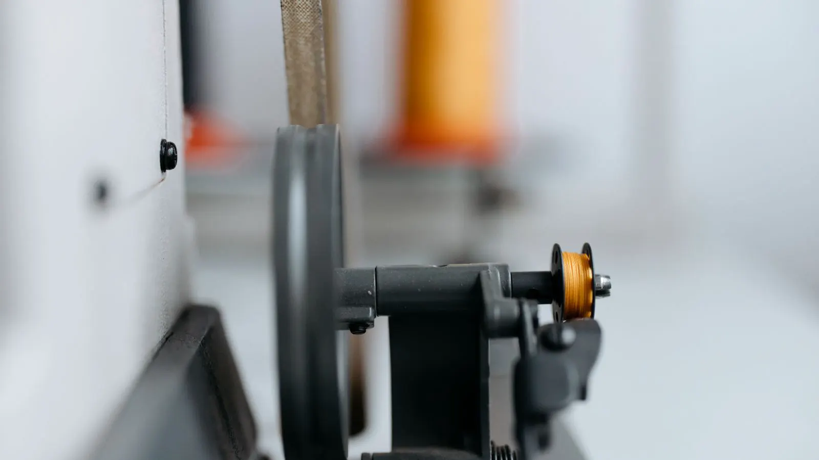 A small metal component coated in orange powder on a production bench