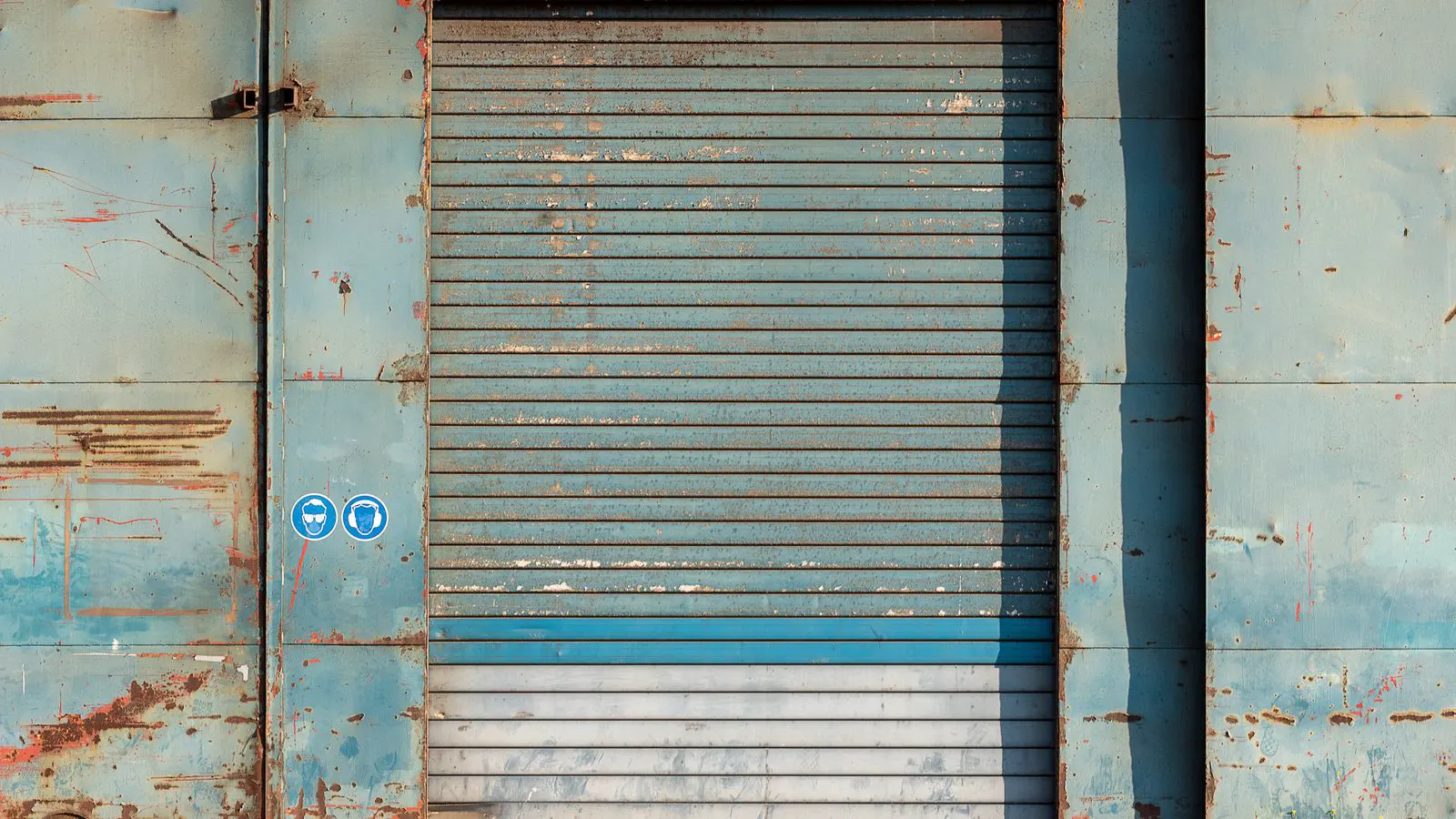 A close-up of a steel surface showing peeling industrial paint layers.