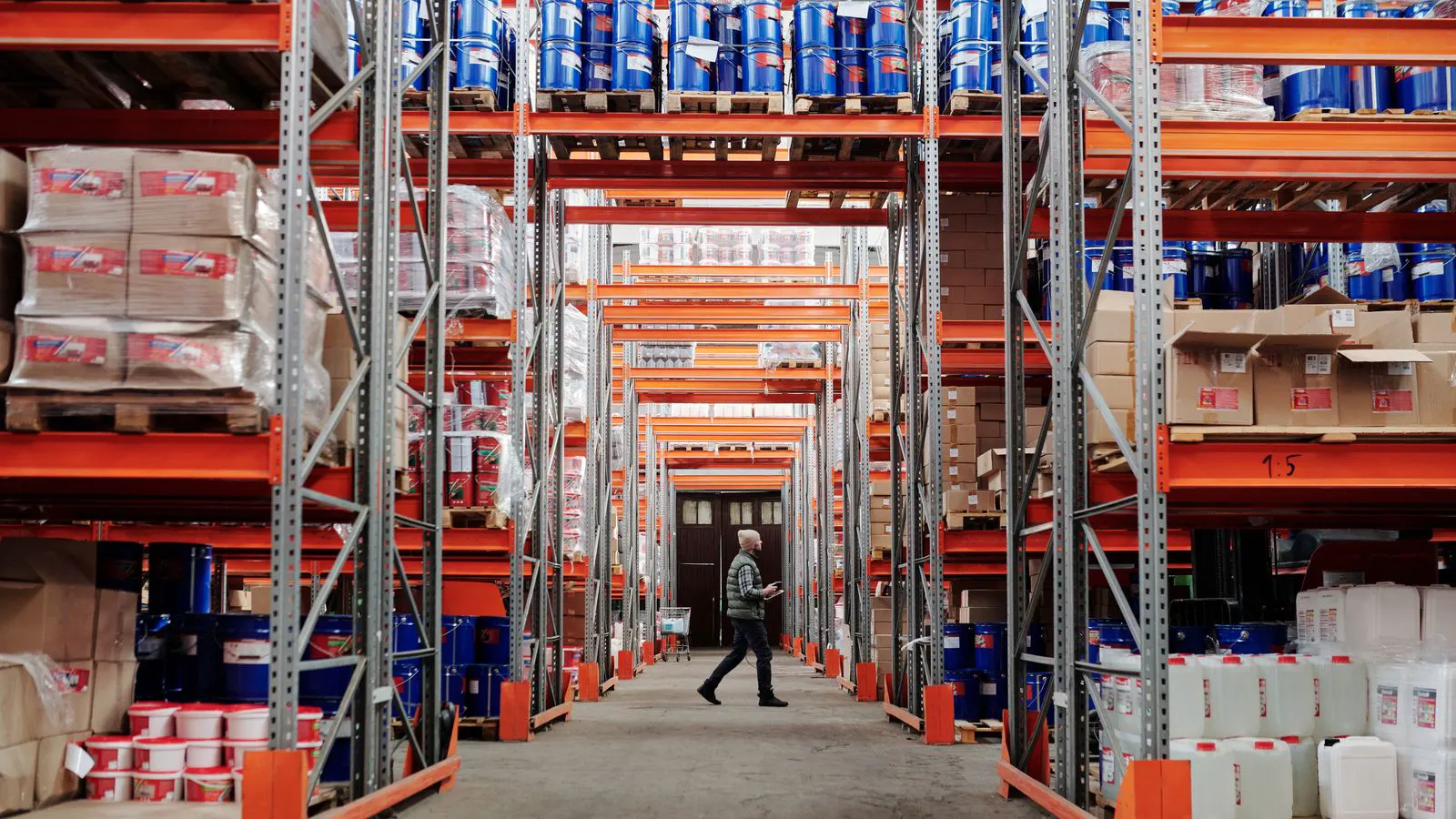 A row of industrial paint barrels stored in a warehouse
