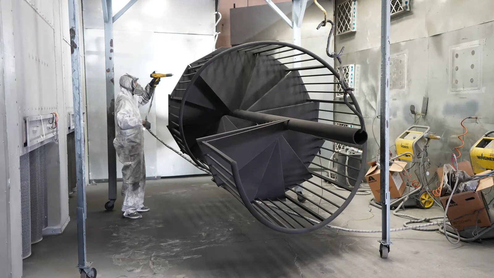 Metal panel receiving even coating inside a spray booth