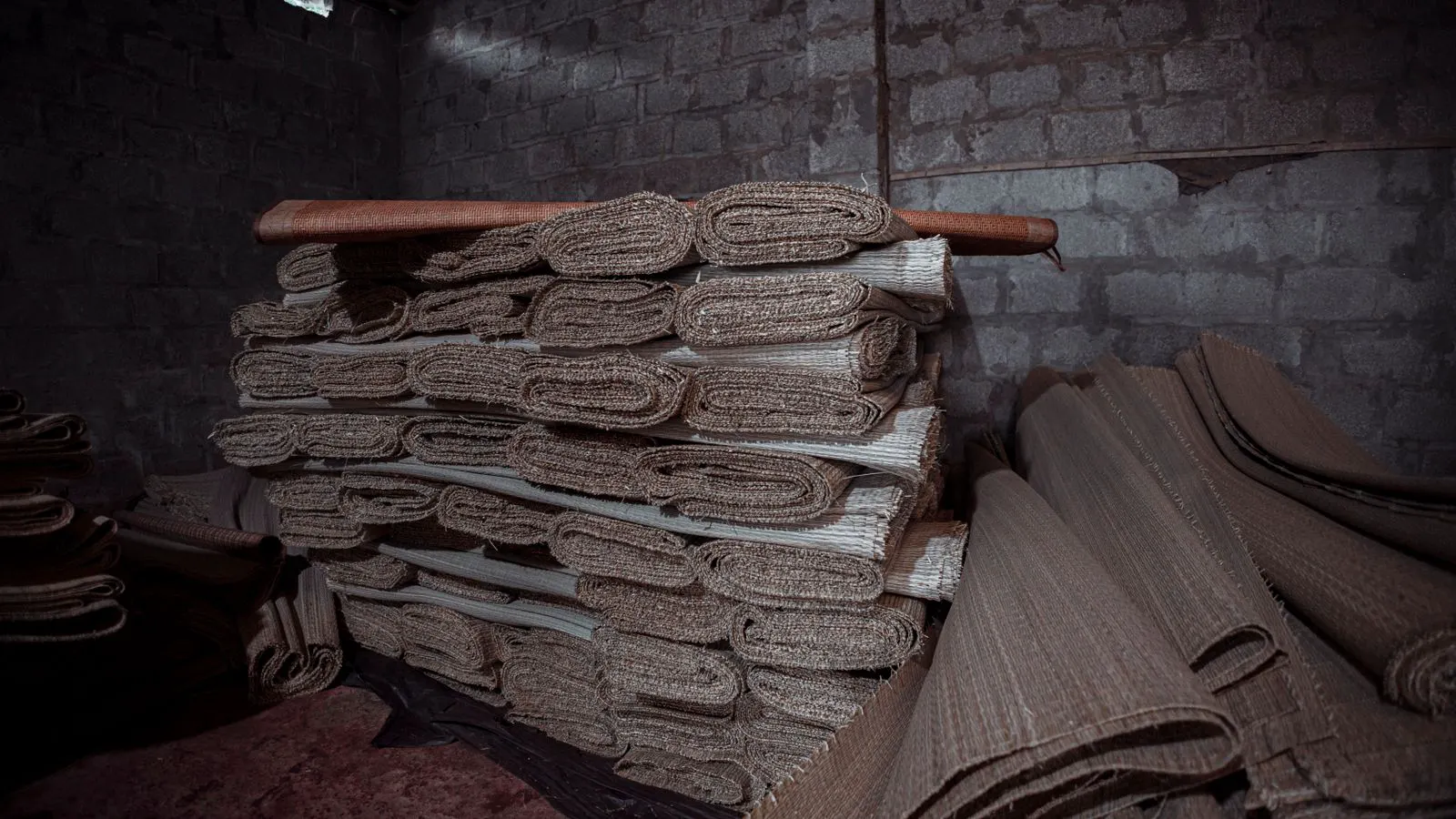 Neatly stacked rolls of composite fabric in a clean warehouse.