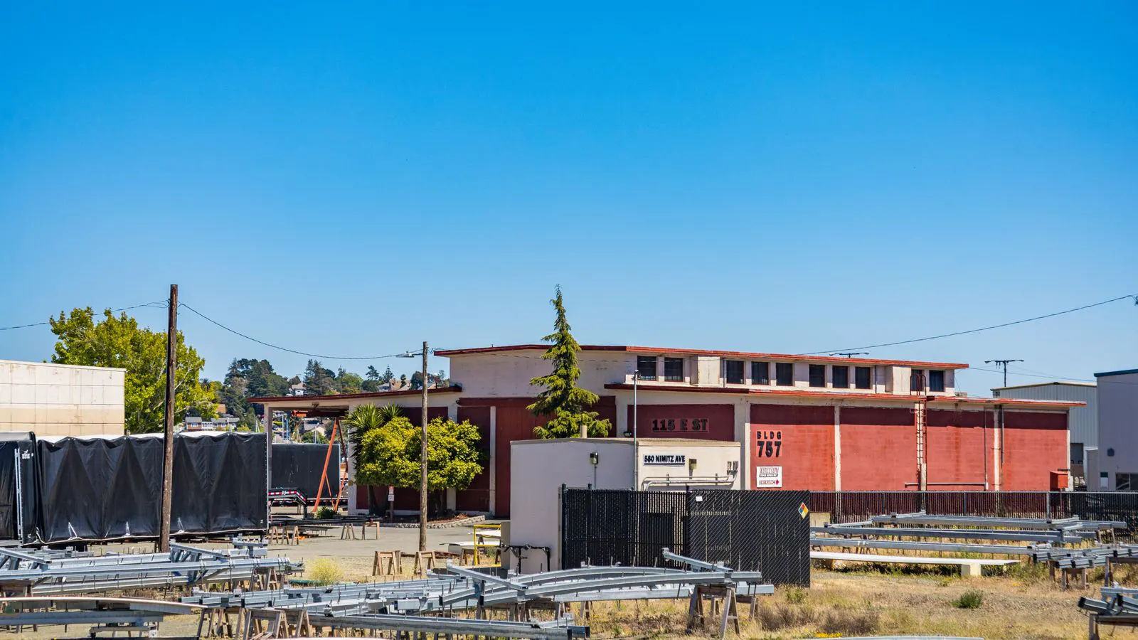 A steel warehouse frame with visible purlins and columns on a construction site