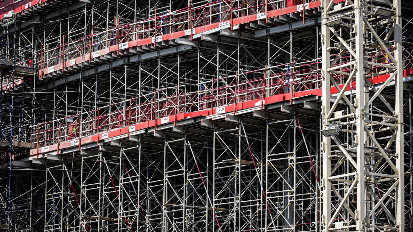Workers inspecting welded steel beams in a fabrication facility