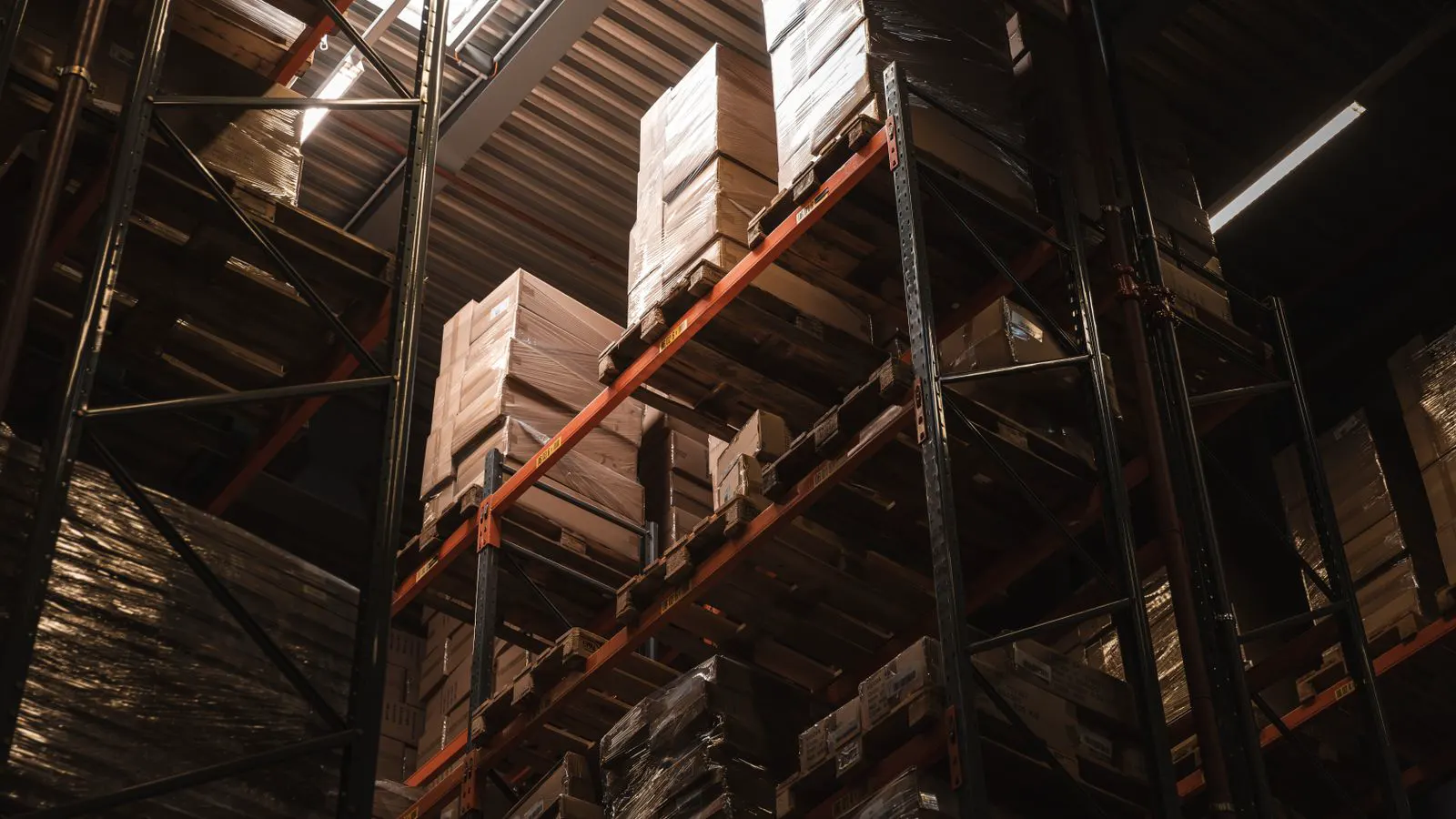 Tall steel warehouse interior with high bay racking and structural beams