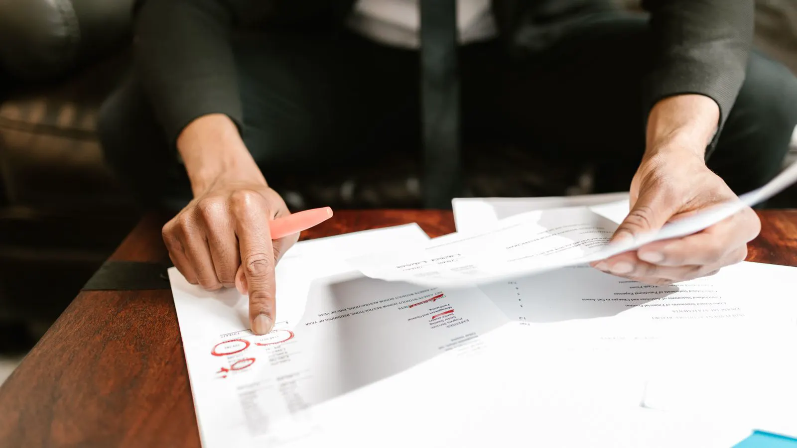 A person reviewing technical drawings and checklists at a desk.