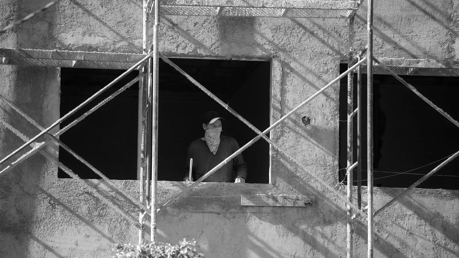 Workers installing a new aluminum window into a building wall