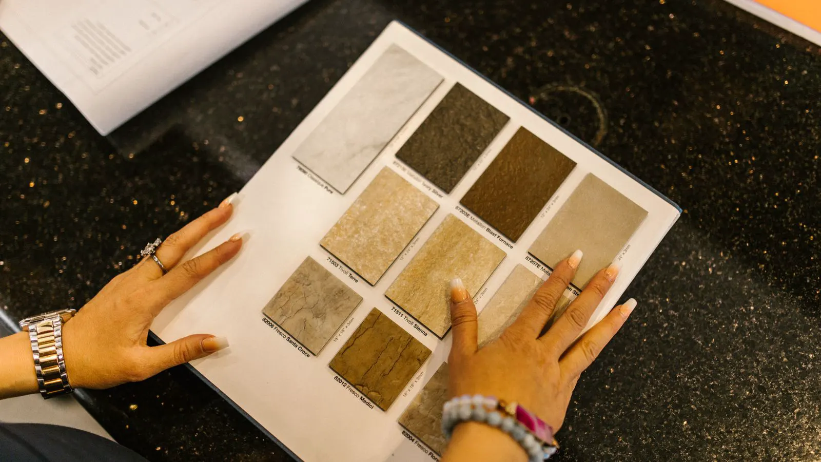 Several commercial vinyl flooring sample tiles arranged on a work table.