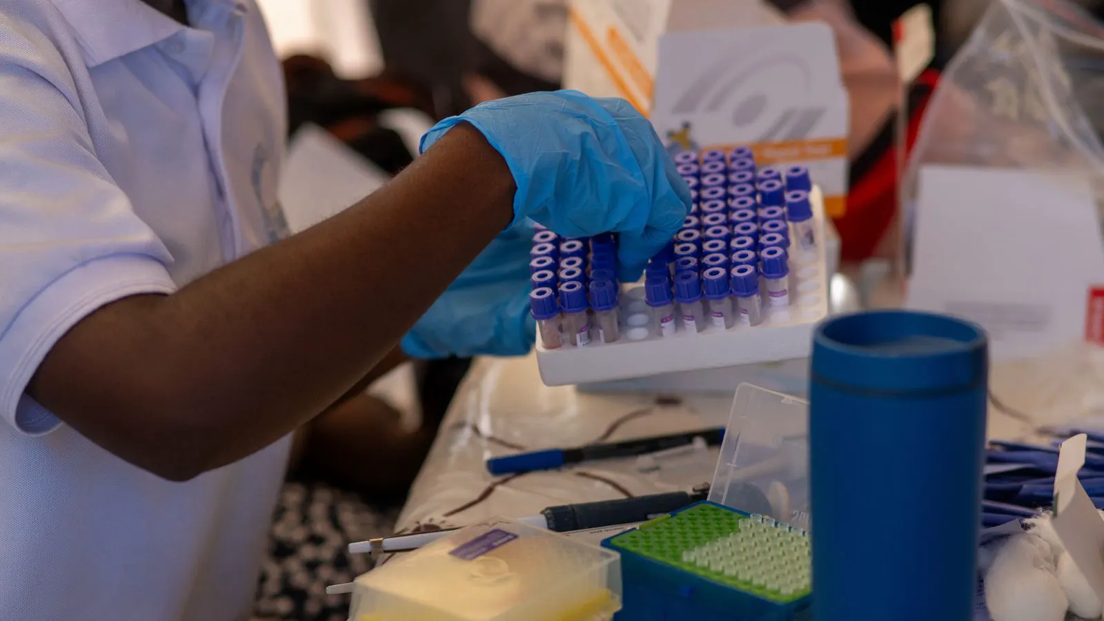 Technician marks a scratch on a ceramic tile sample in a lab