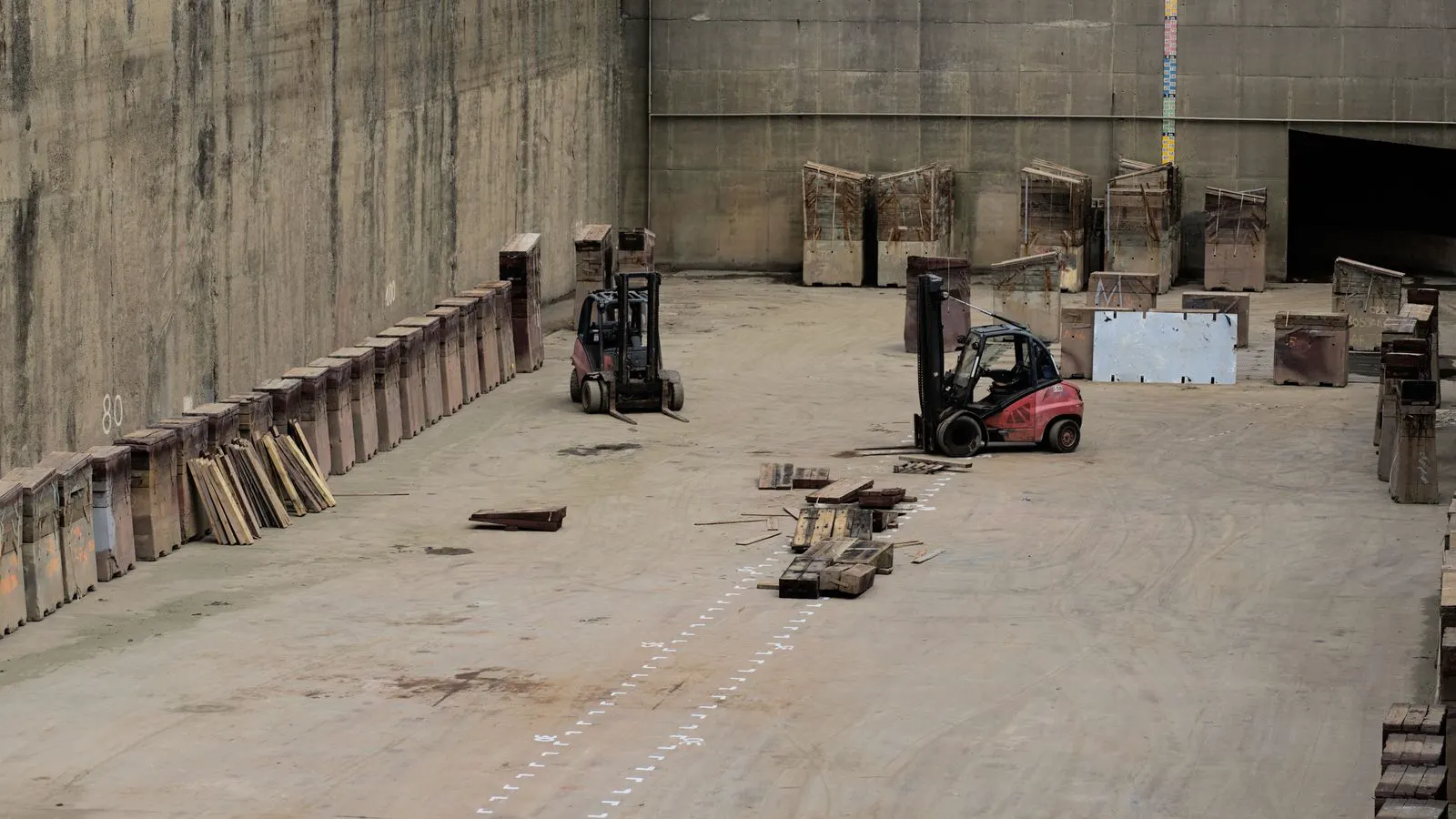A large cut stone slab resting on wooden supports in a warehouse.