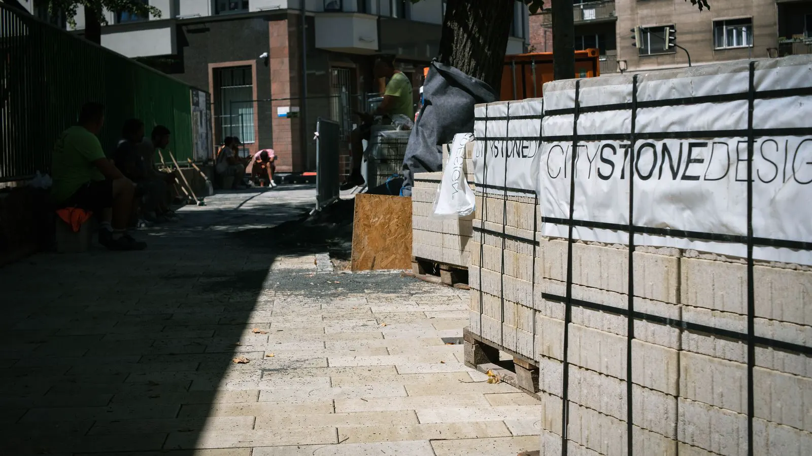 Construction crew unloading natural stone slabs from a delivery truck