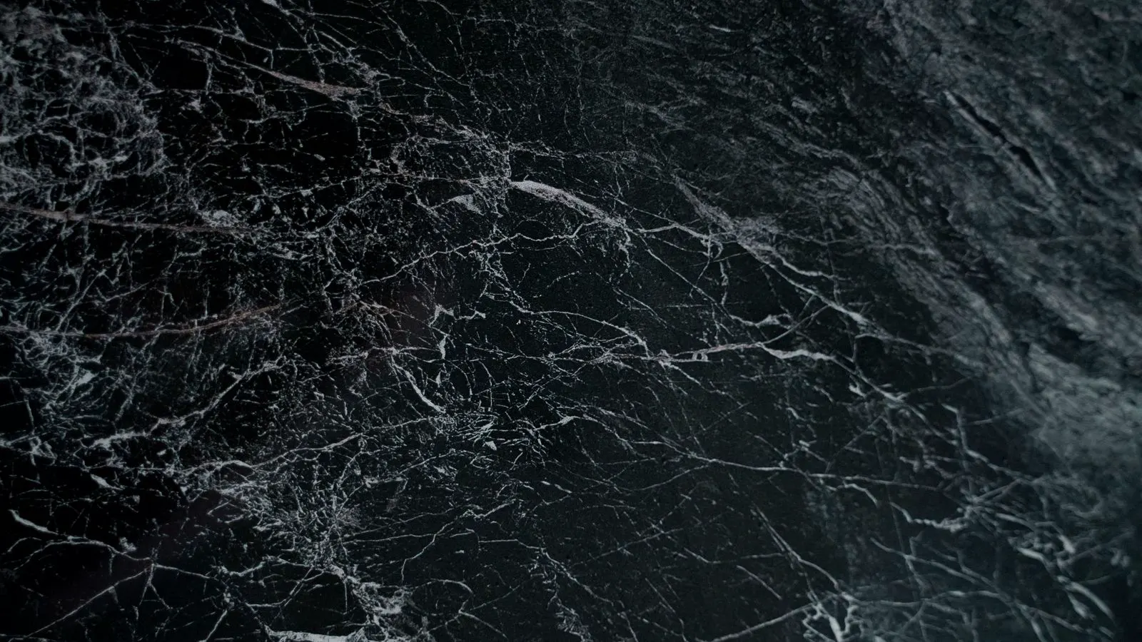 Technician polishing a scratched marble floor section in a lobby