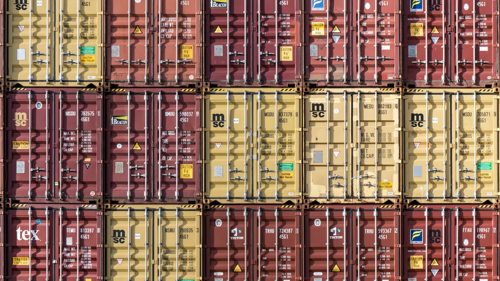 A cargo container loaded with stone slabs at a port