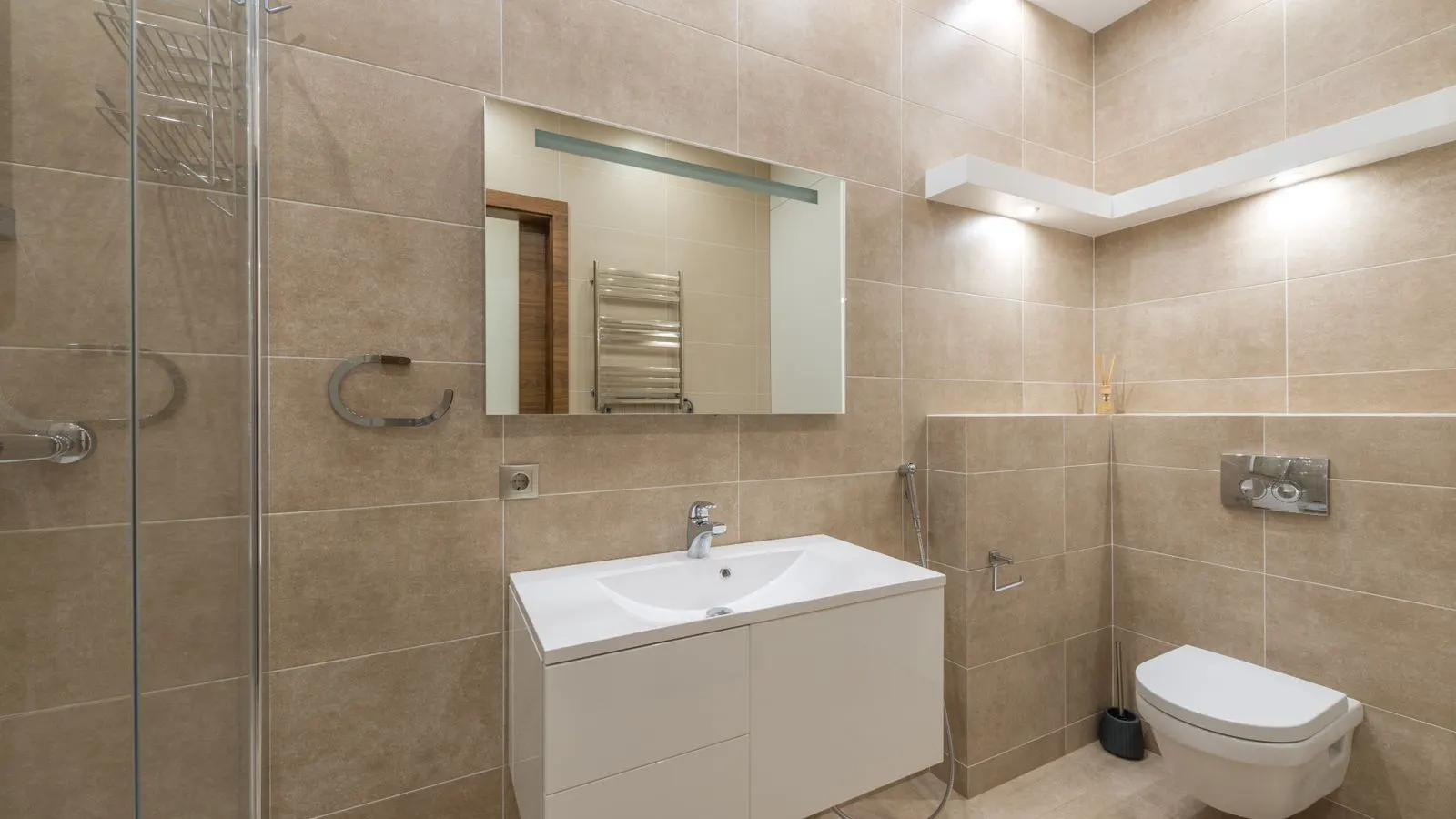 A modern public restroom featuring a digital flush control panel on a toilet