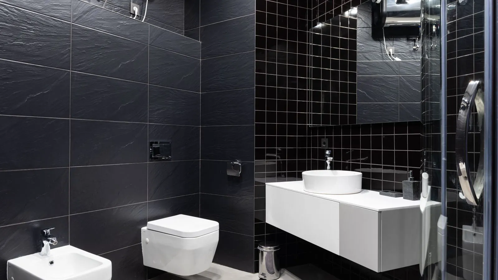 A hand wiping a clean white ceramic tile next to a chrome tap.