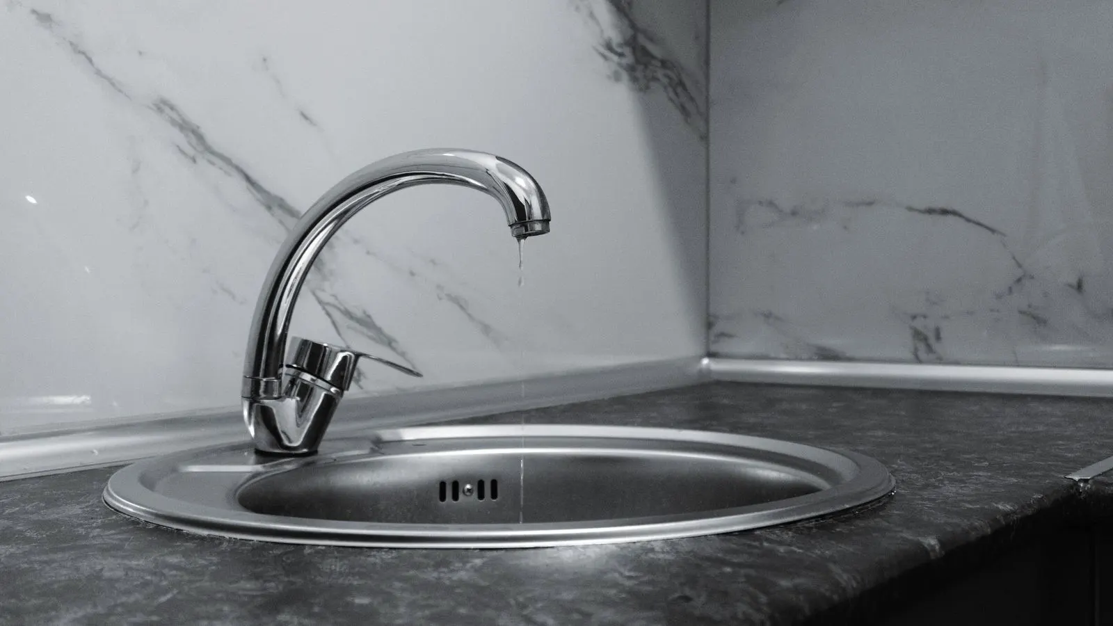 A chrome faucet showing water spots on its polished surface