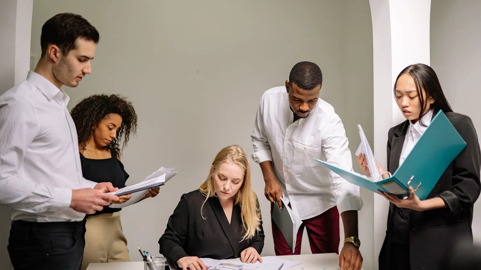Two engineers reviewing supplier documentation at a workstation.