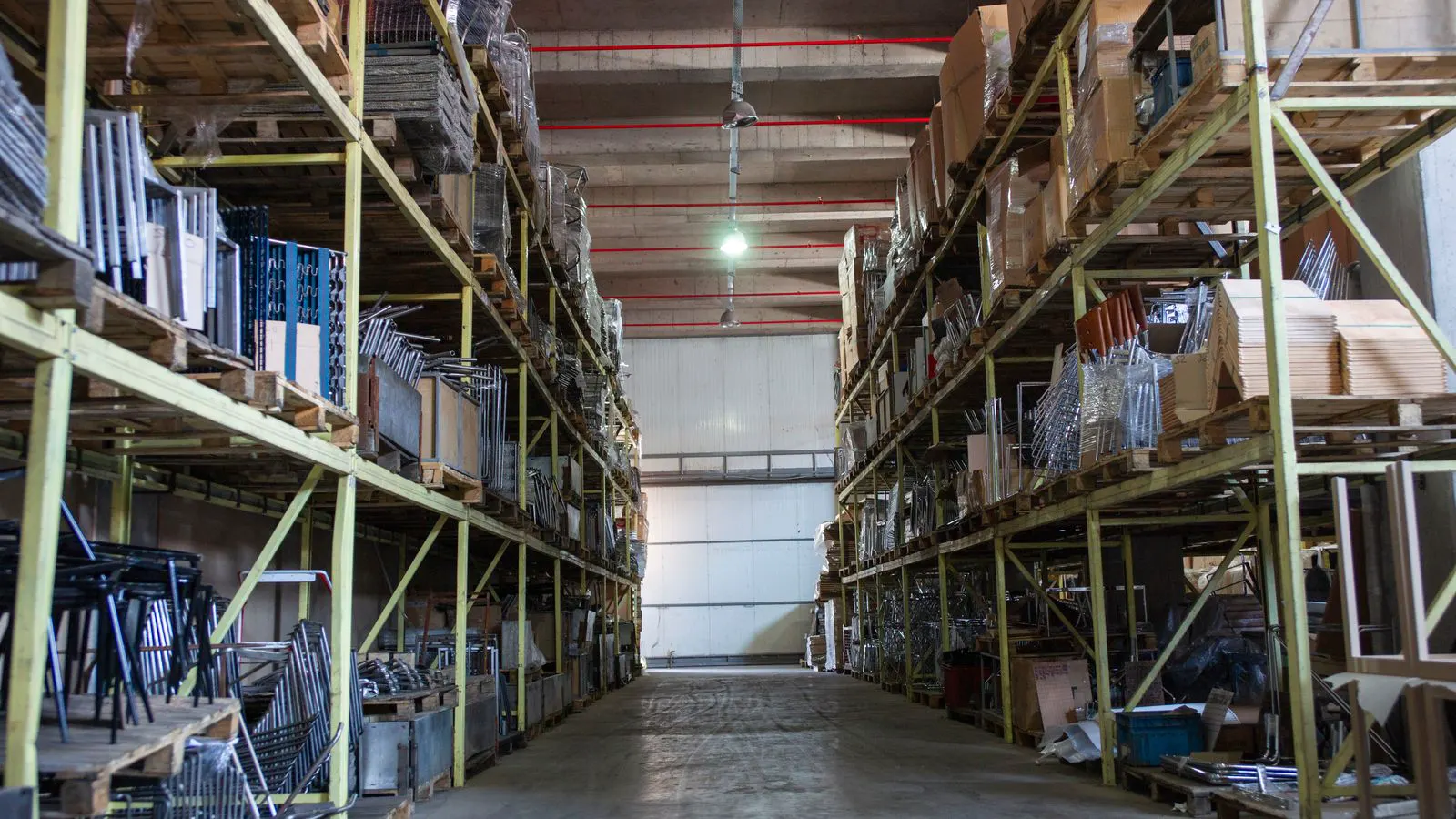 Industrial shelving holding stacked air conditioning units in a storage facility.