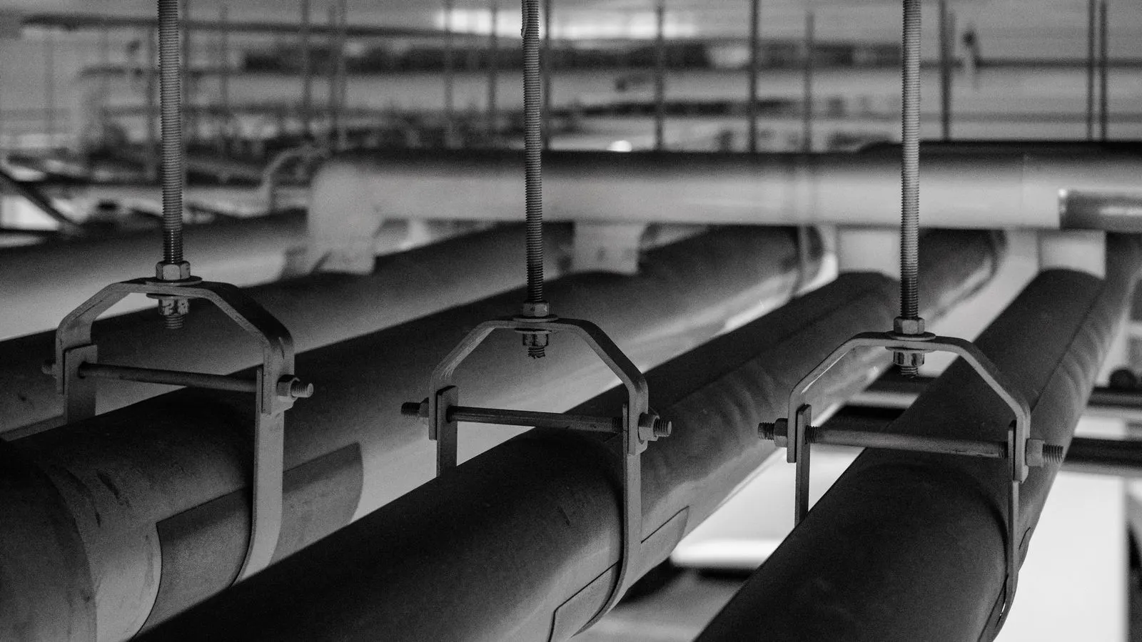 A close-up of silver stainless steel pipe fittings on a workbench.