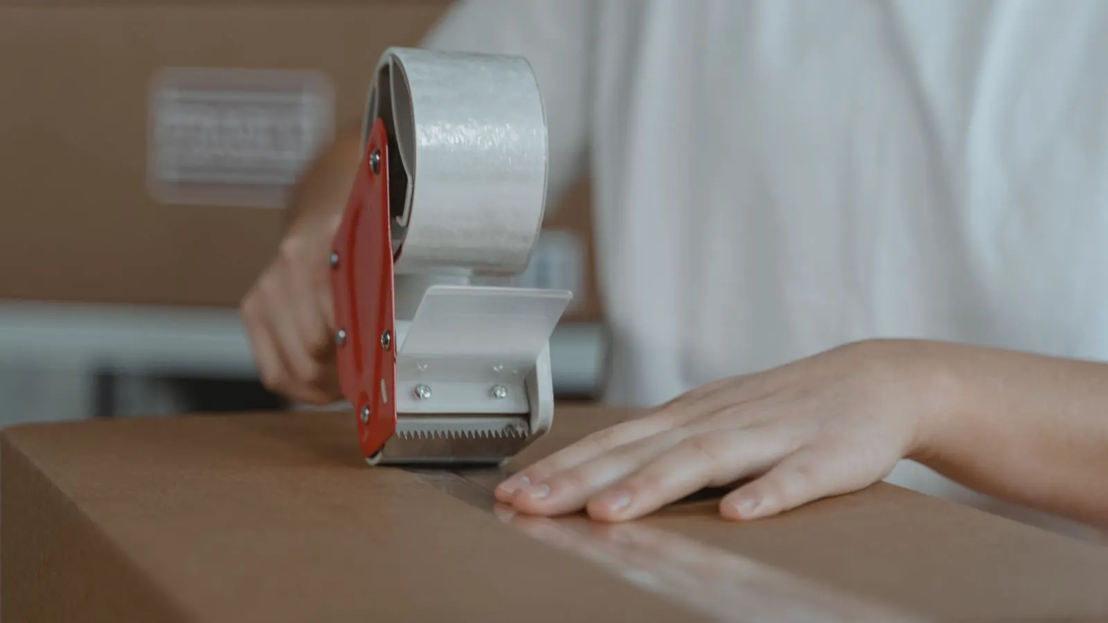 A compression frame testing a corrugated box under controlled weight.