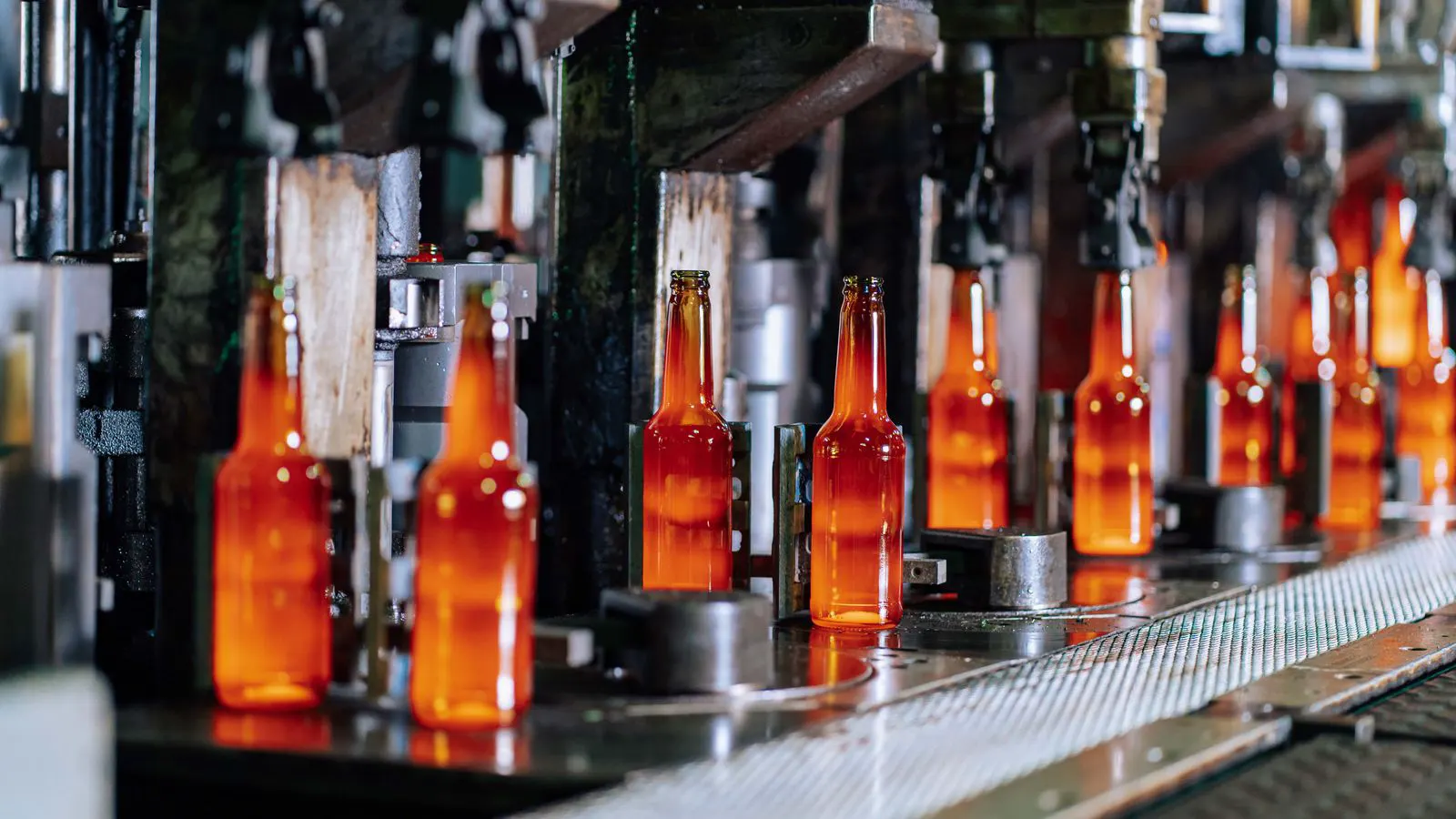 A factory line assembling clear and colored glass bottles.