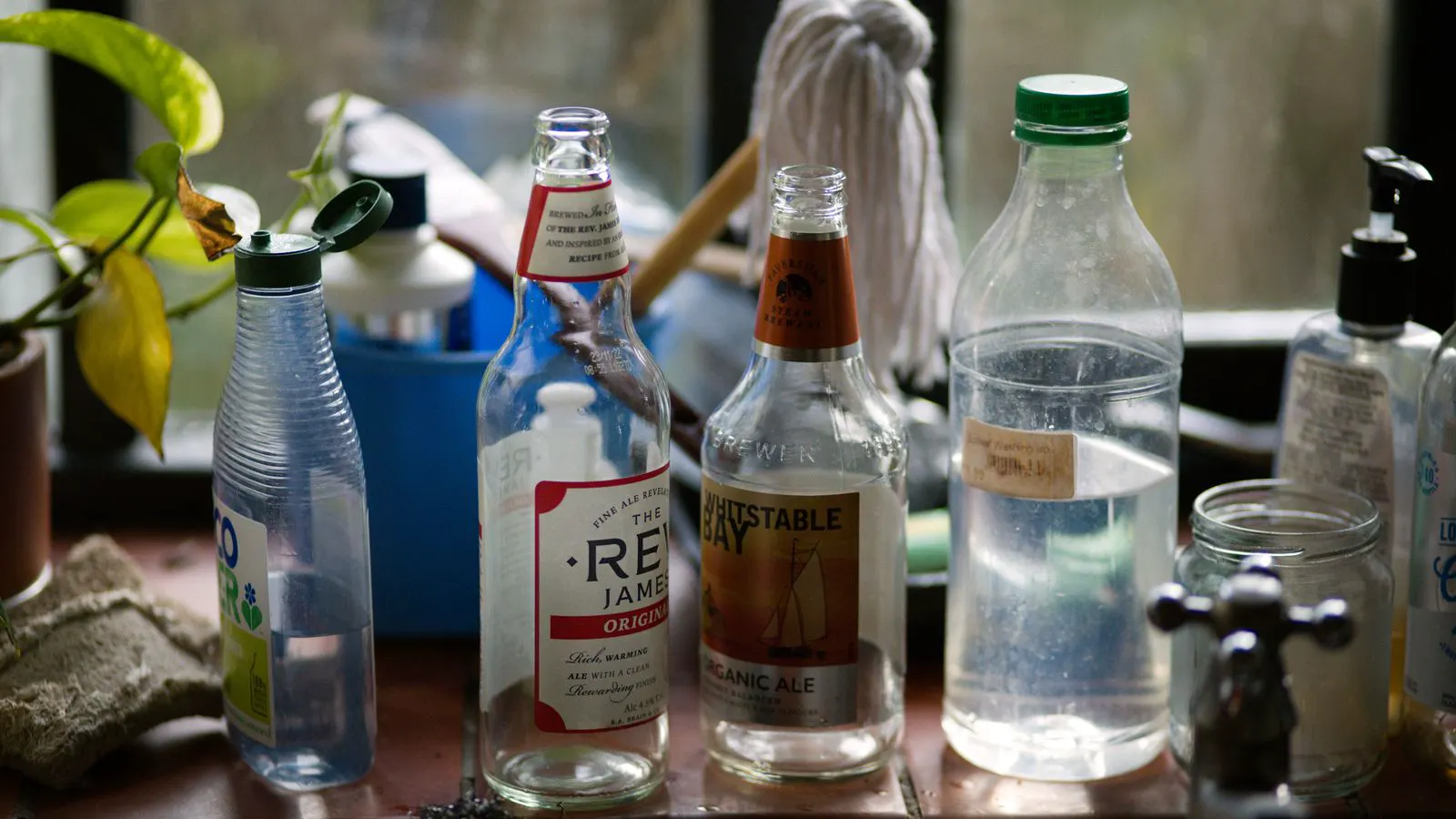 Several clear and opaque plastic bottles arranged on a workbench.