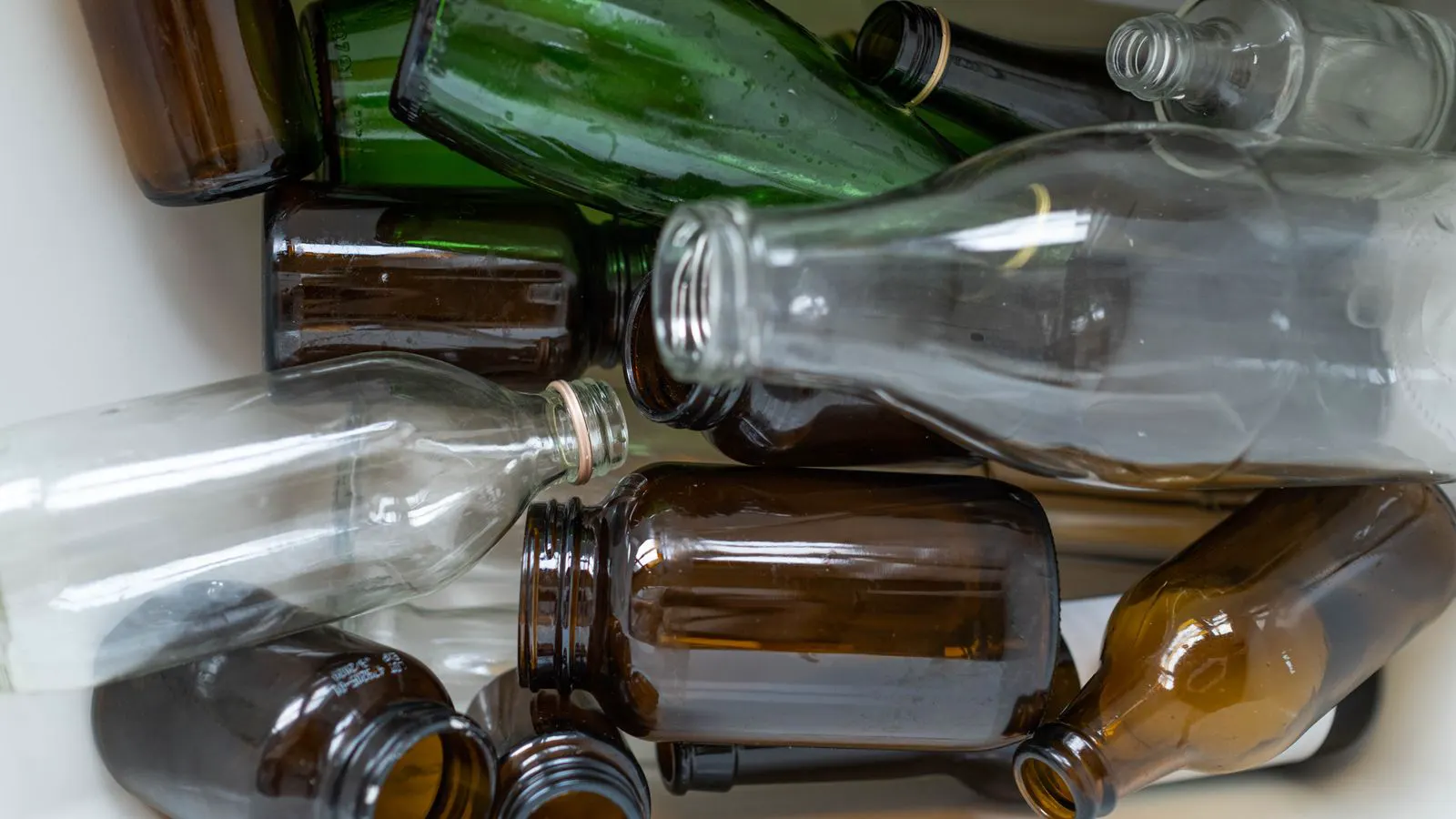 A row of clear glass bottles with metal caps on a workbench