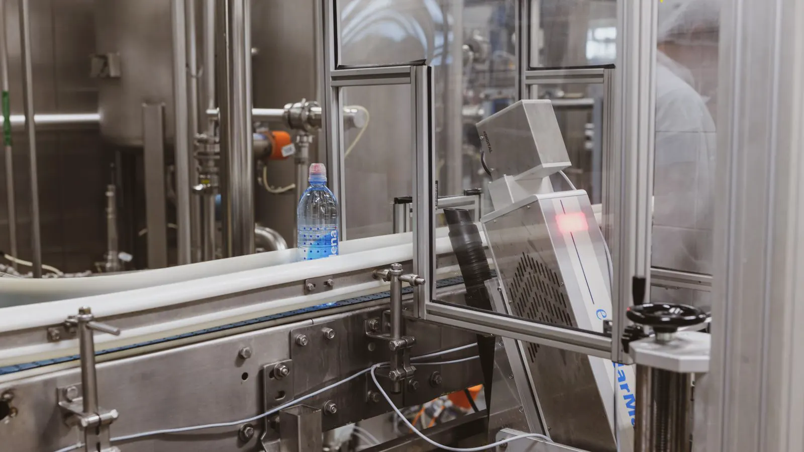 A row of clear plastic bottles moving along a production line