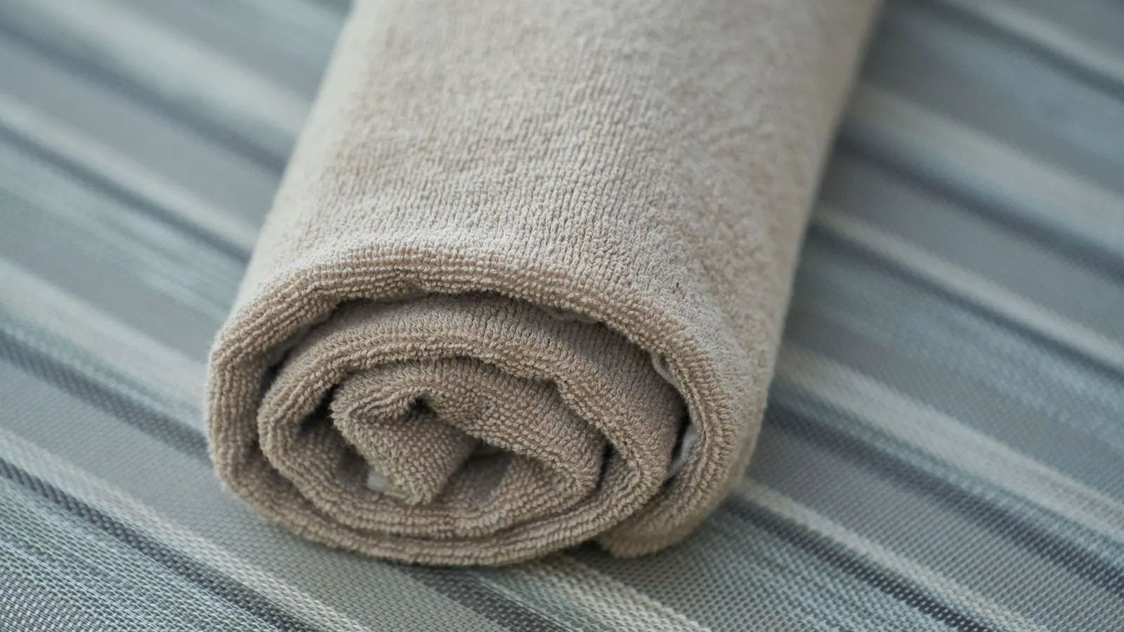 A roll of plain cotton fabric on a factory table.