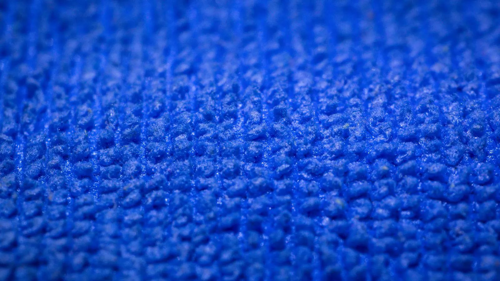 Close up view showing loose fibers at the edge of a white nonwoven fabric sample.