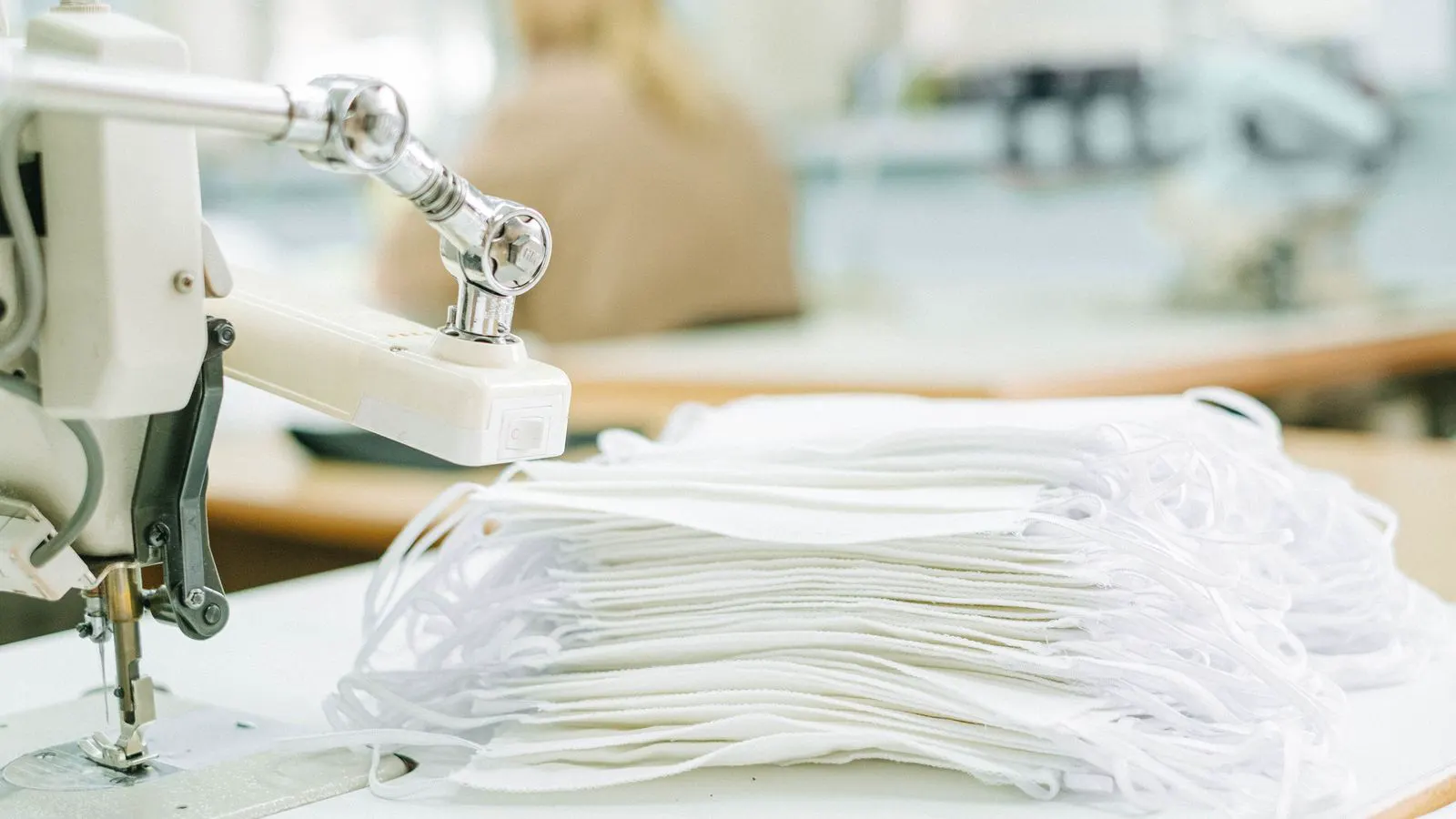 A worker inspecting a roll of white nonwoven fabric
