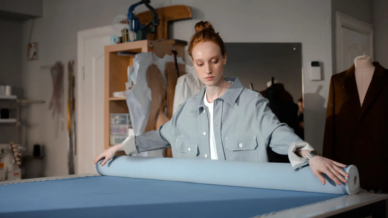 A roll of white polypropylene spunbond fabric on a metal stand