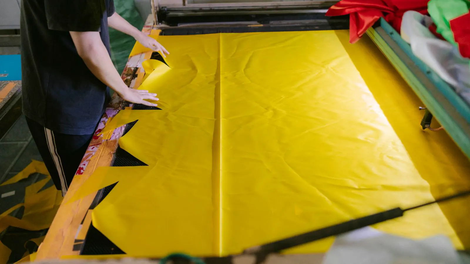 A large roll of white nonwoven fabric sitting on a production line floor