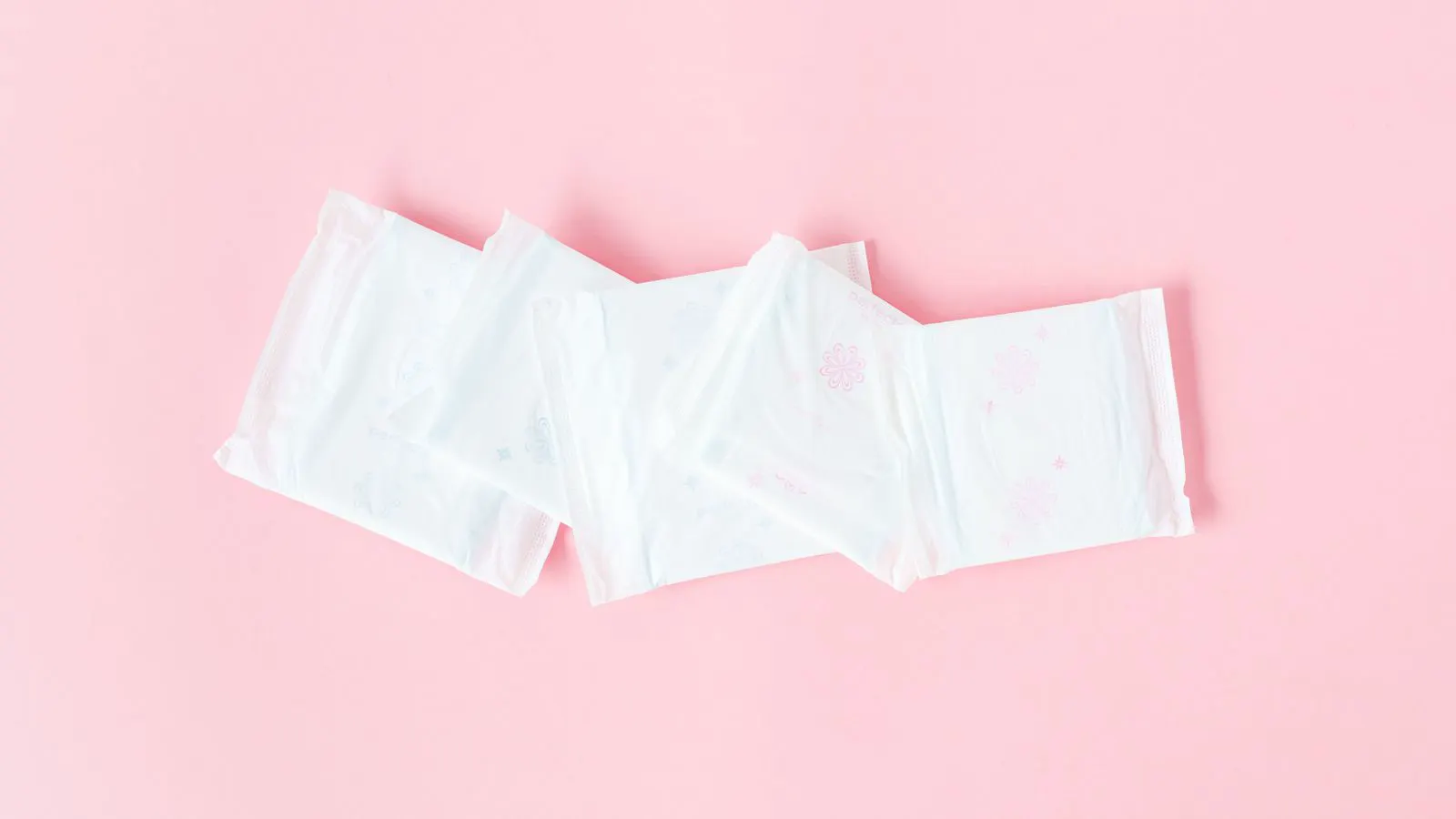 A large roll of white nonwoven fabric on a production line
