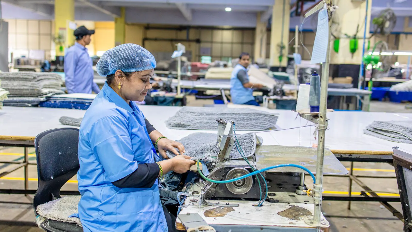 Fabric pieces being prepared for sewing on a factory floor