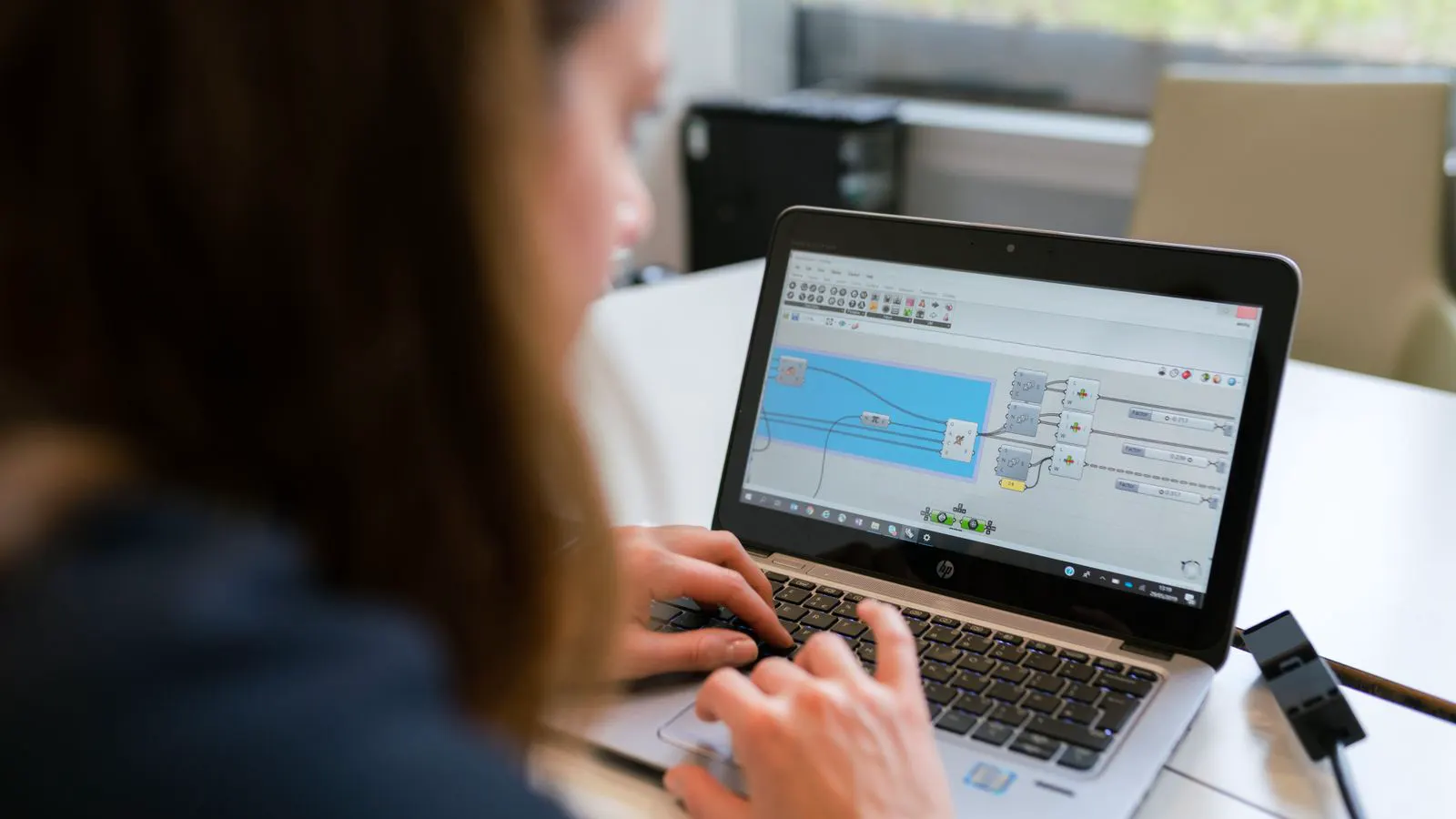 An engineer reviews a virtual garment model on a tablet screen.