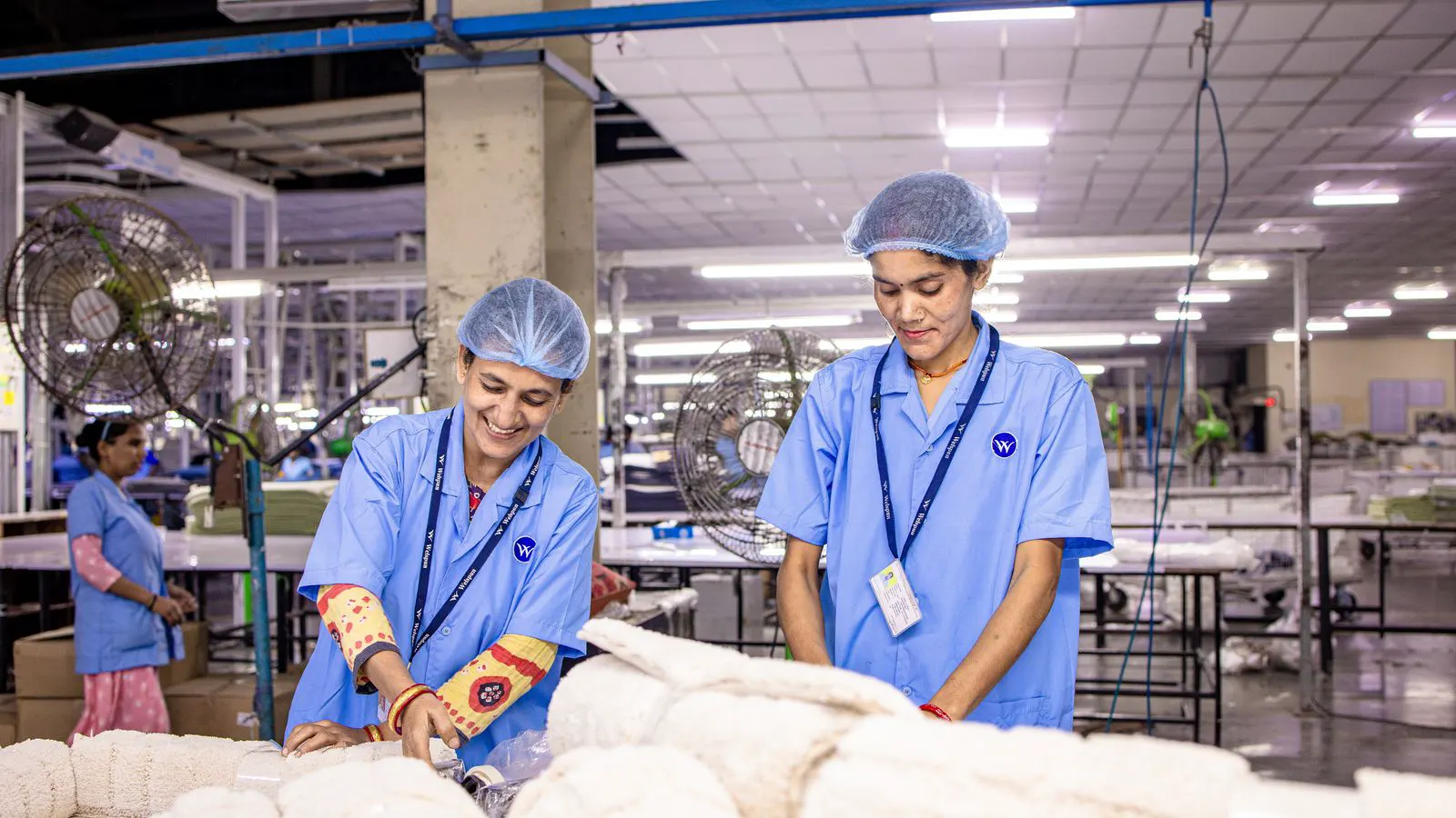 A factory supervisor reviewing a compliance checklist with production staff