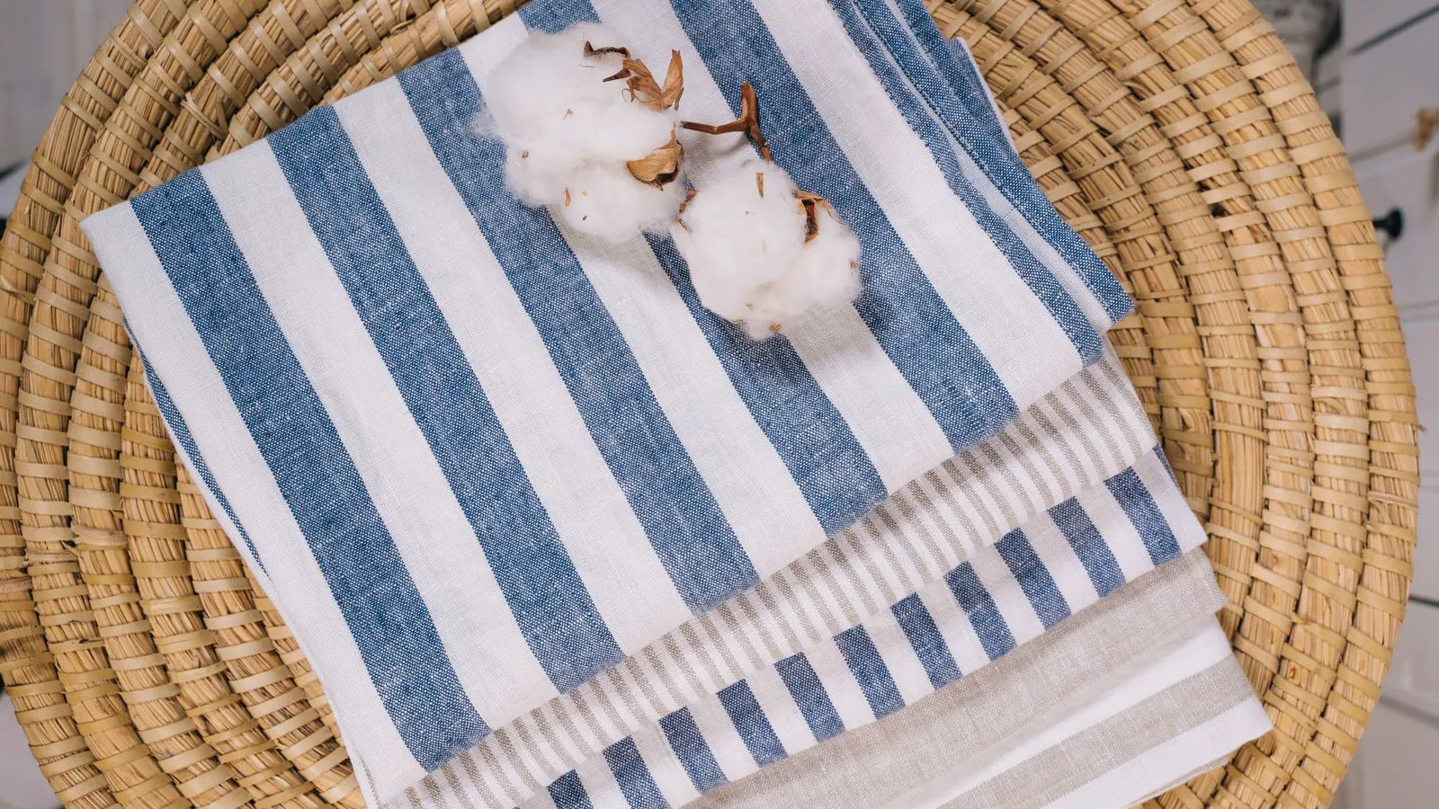 A stack of white cotton towels hanging on a drying rack