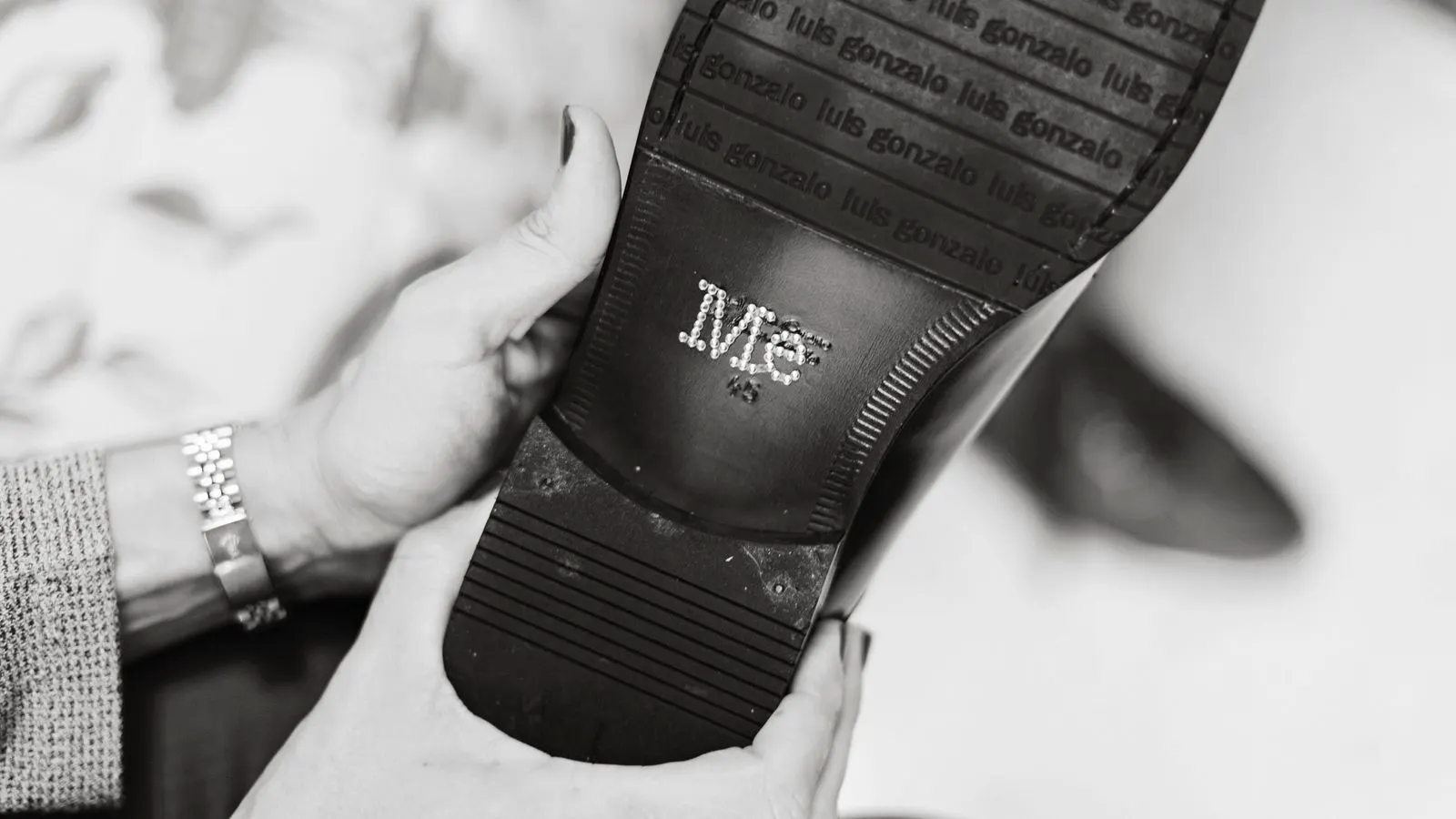 Inspector checking the tread pattern and stitching on a leather shoe