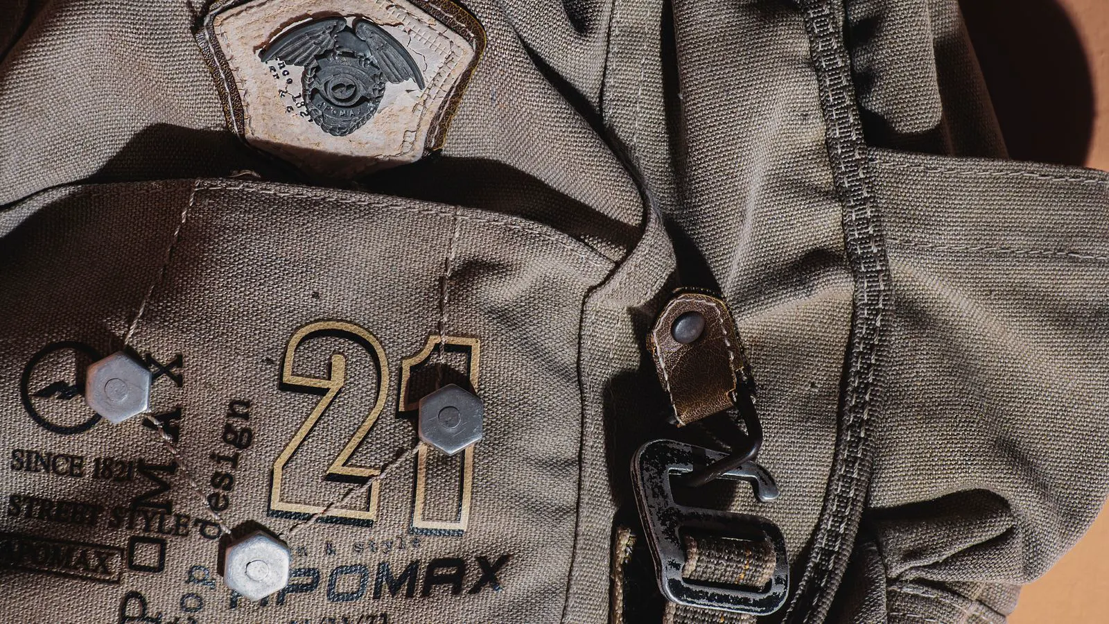 Close up view of metal grommets attached to canvas backpack straps